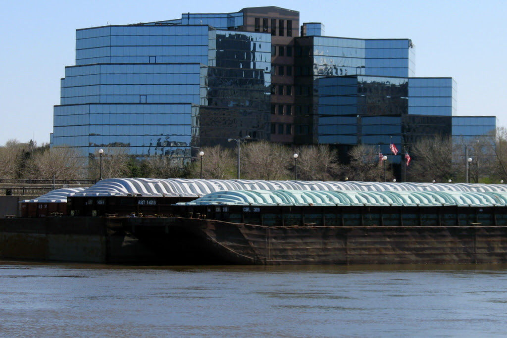 all glass building with a Mississippi River barge parked in front of it