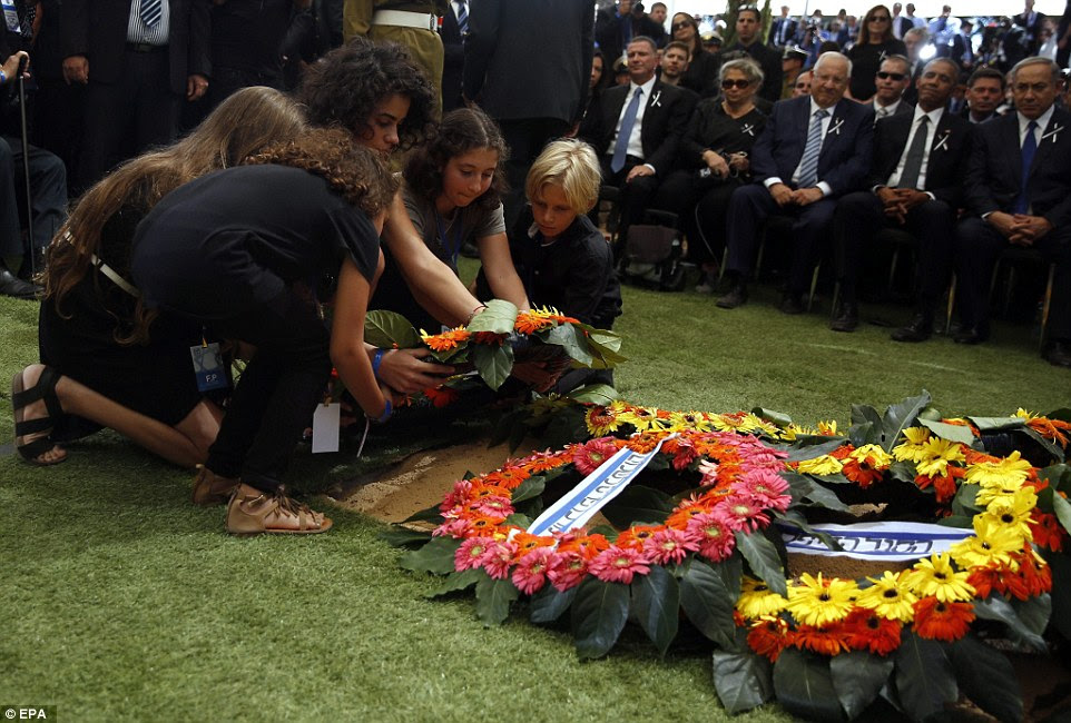Pungente: Os netos de Shimon Peres colocar uma coroa de flores no túmulo de seu avô durante a cerimônia de enterro como um presidente Obama olha e sorri tristemente