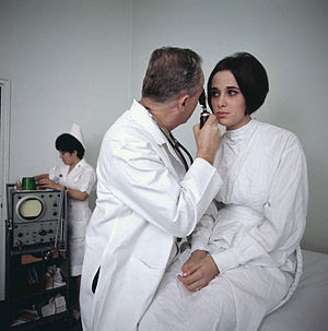 English: A doctor examines a female patient.