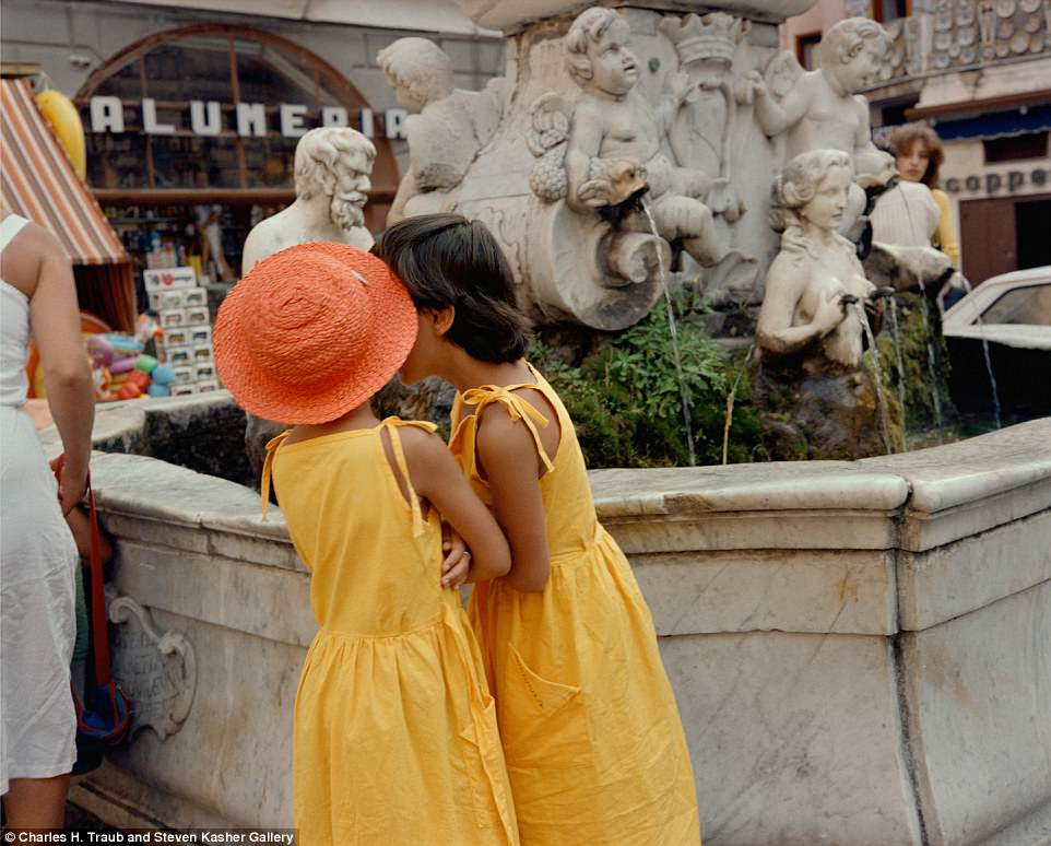 Charles H. Traub travelled extensively to Italy for his Dolce Via project, visiting particular areas for two or three weeks at a time. Here, two girls in matching dresses whisper by a fountain in Siena in 1983