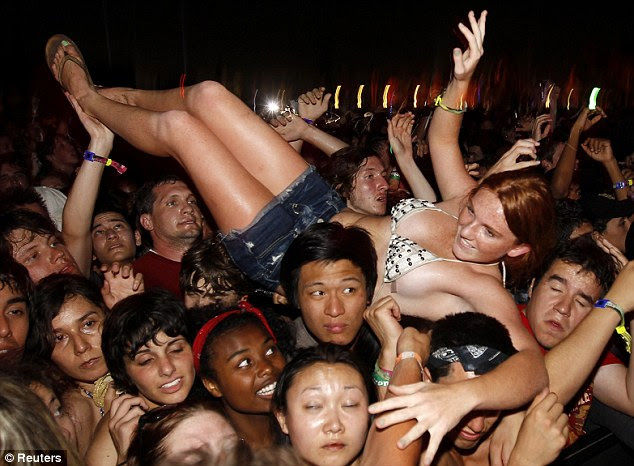 Crowd surfing: A woman is gets lifted up during the Strokes's performance