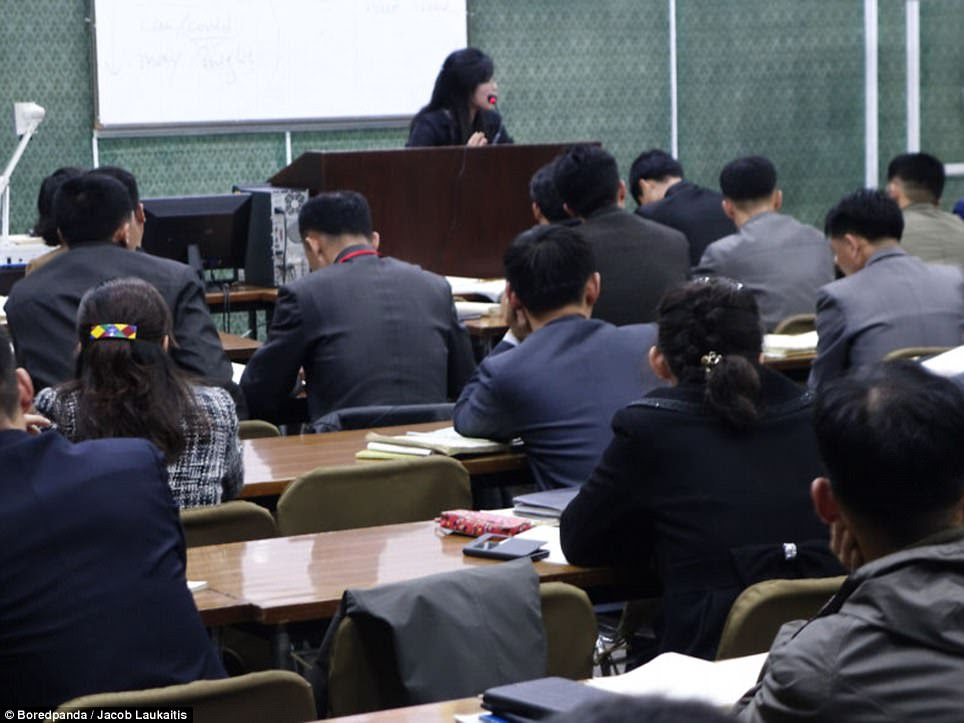 But moving to North Korea, a classroom setting appears rigid and bleak as students sit in uniform with their heads studiously bowed