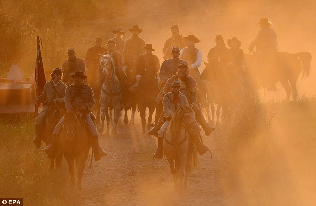 Red night: Re-enactors portraying Confederate cavalry pass through a cloud of dust at sunset on September 14, during preparation for the 150th Anniversary Reenactment of the Civil War Battle of Antietam