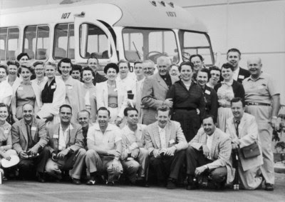 Amway Co-Founders Rich DeVos and Jay Van Andel (bottom row, second and third from the right, respectively) and their group of senior key agents pose with Nutrilite Founder Carl F. Rehnborg and his wife Edith Rehnborg, in front of their tour bus, 1956.