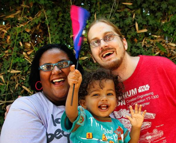 Faith Cheltenham's 1-year-old son Storm waves a flag honoring bisexuals before heading to a Fourth of July gathering with her husband, Matt Kanninen. Faith is a bisexual activist and is vocal about the "B" being ignored in the LGBT community.