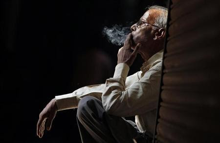 A daily wage labourer smokes as he waits for an employer in the old quarters of Delhi, April 29, 2010. REUTERS/Adnan Abidi