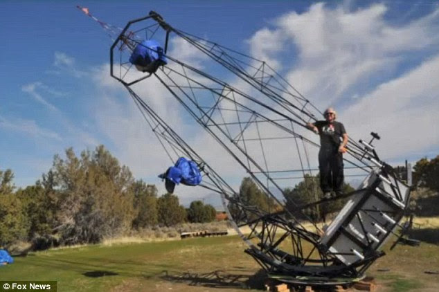 Enormous: Utah man Mike Clements stands proudly aloft his 35-feet tall telescope he built from the remnants of a Cold War satellite