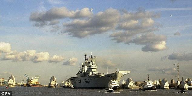 Sorry ending: The Royal Navy's flagship aircraft carrier HMS Ark Royal, pictured sailing through the Thames barrier in central London, will be sold off as scrap metal