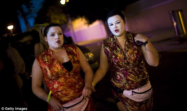 Culture clash: Two young women match geisha-style makeup with pink bum bags for a night out in the Costa Dorada resort 