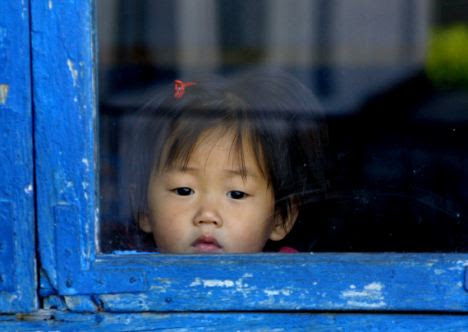 No birthdays: a child looks out of a kindergarten in North Korea