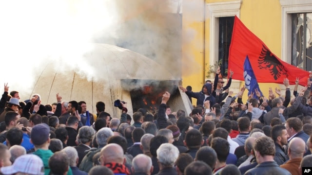 Albanian opposition supporters burn a bunker that would serve as the entrance of a former communist regime-used tunnel to be turned into a museum in Tirana, Dec. 8, 2015.