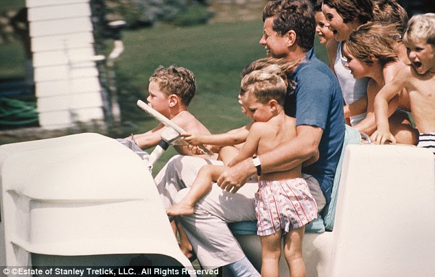 All the president's men: JFK takes the Kennedy, Shriver, Smith and Lawford children for a ride on his golf cart at the family's compound in Hyannis Port