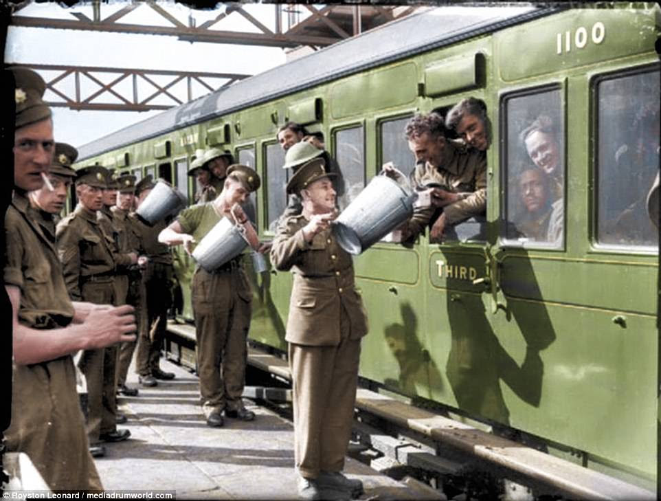 Smiling soldiers smoke while others fill up their canteens on board a train during the evacuation of Dunkirk in 1940
