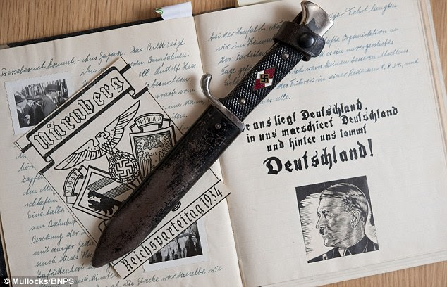 Up for sale: A Hitler Youth dagger with swastika on the handle and a portrait of Hitler with slogans in the diaries