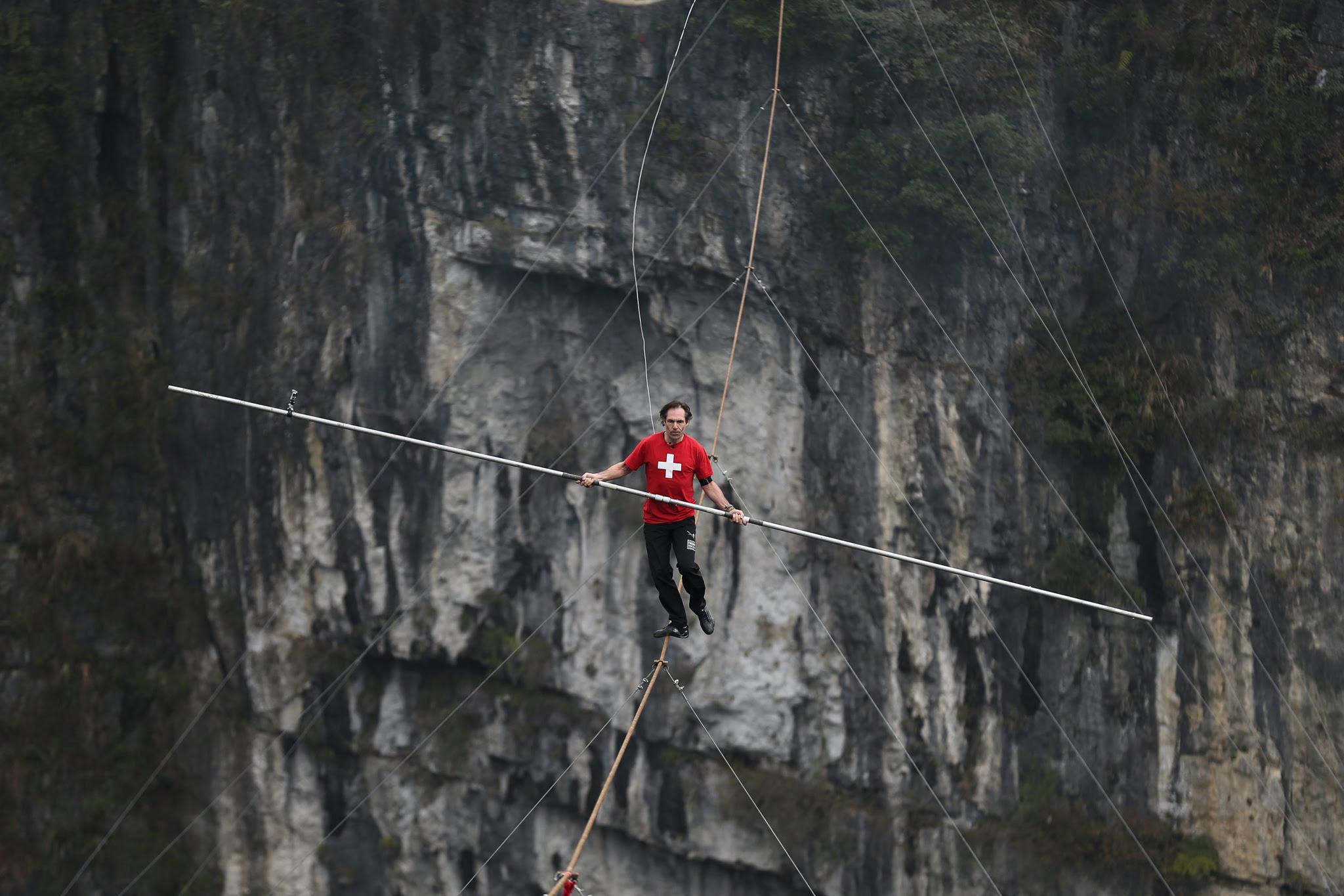 Freddy Nock of Switzerland walks on tightrope during a competition in Wulong county, Chongqing, China, March 30, 2016.