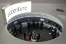 Visitors look at devices at Accenture stand at the Mobile World Congress in Barcelona