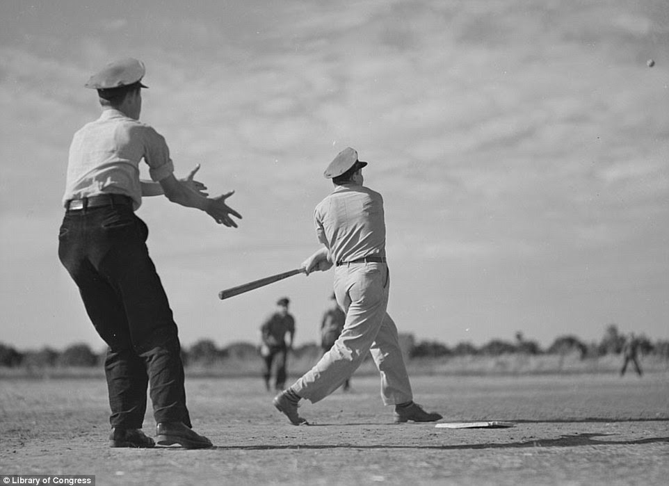 The dry, cracked soil doubled as a baseball diamond in Weslaco, Texas where men enjoy a home run in February 1942