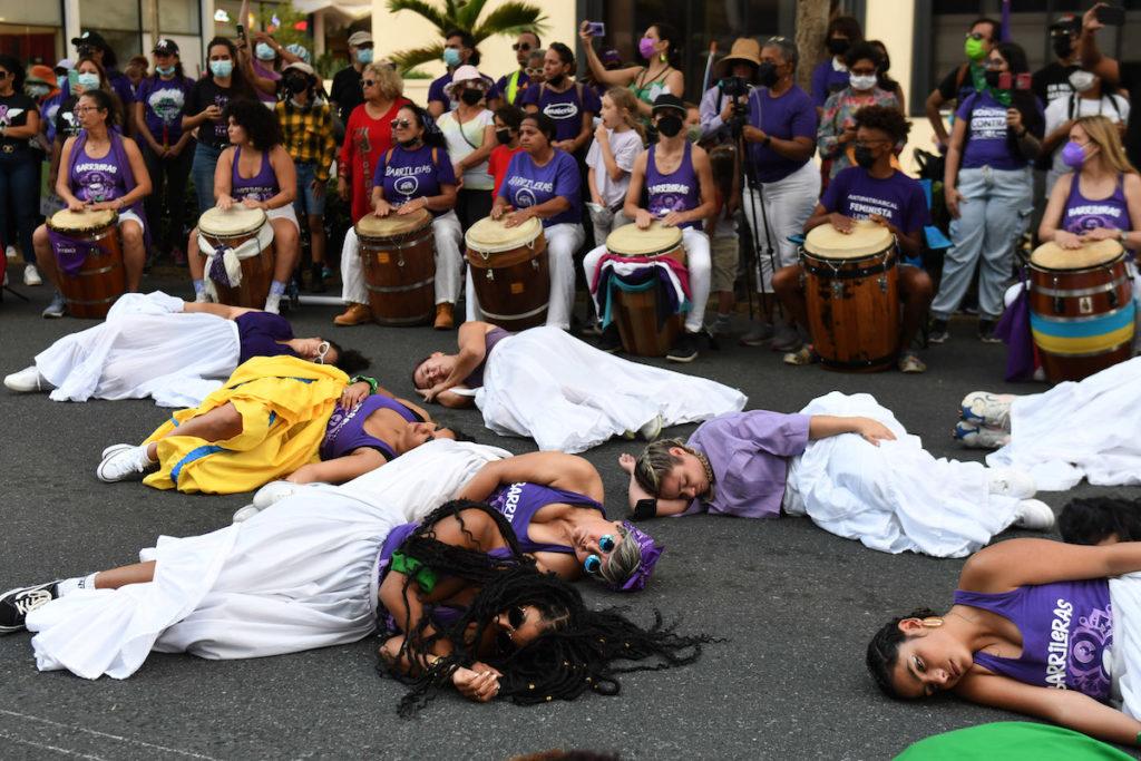 A group of people lying on the ground with drums in the back

Description automatically generated with medium confidence