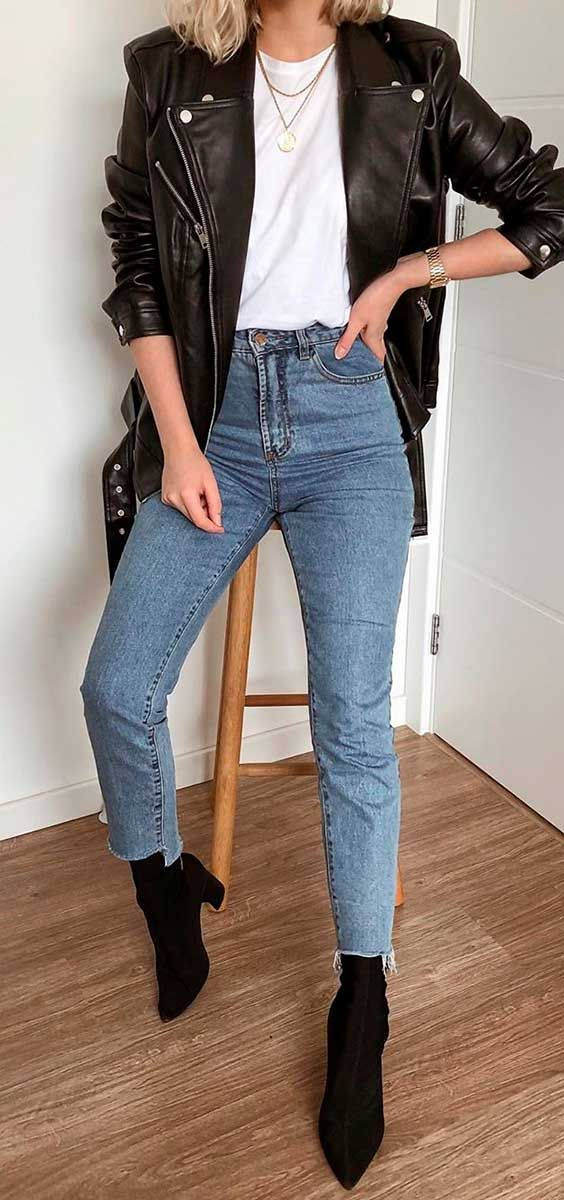 mulher com o clássico look de jaqueta de couro com calça jeans e bota preta