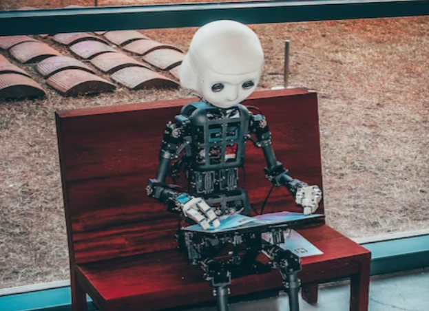 Stock image from Unsplash of a robot sitting on a bench reading