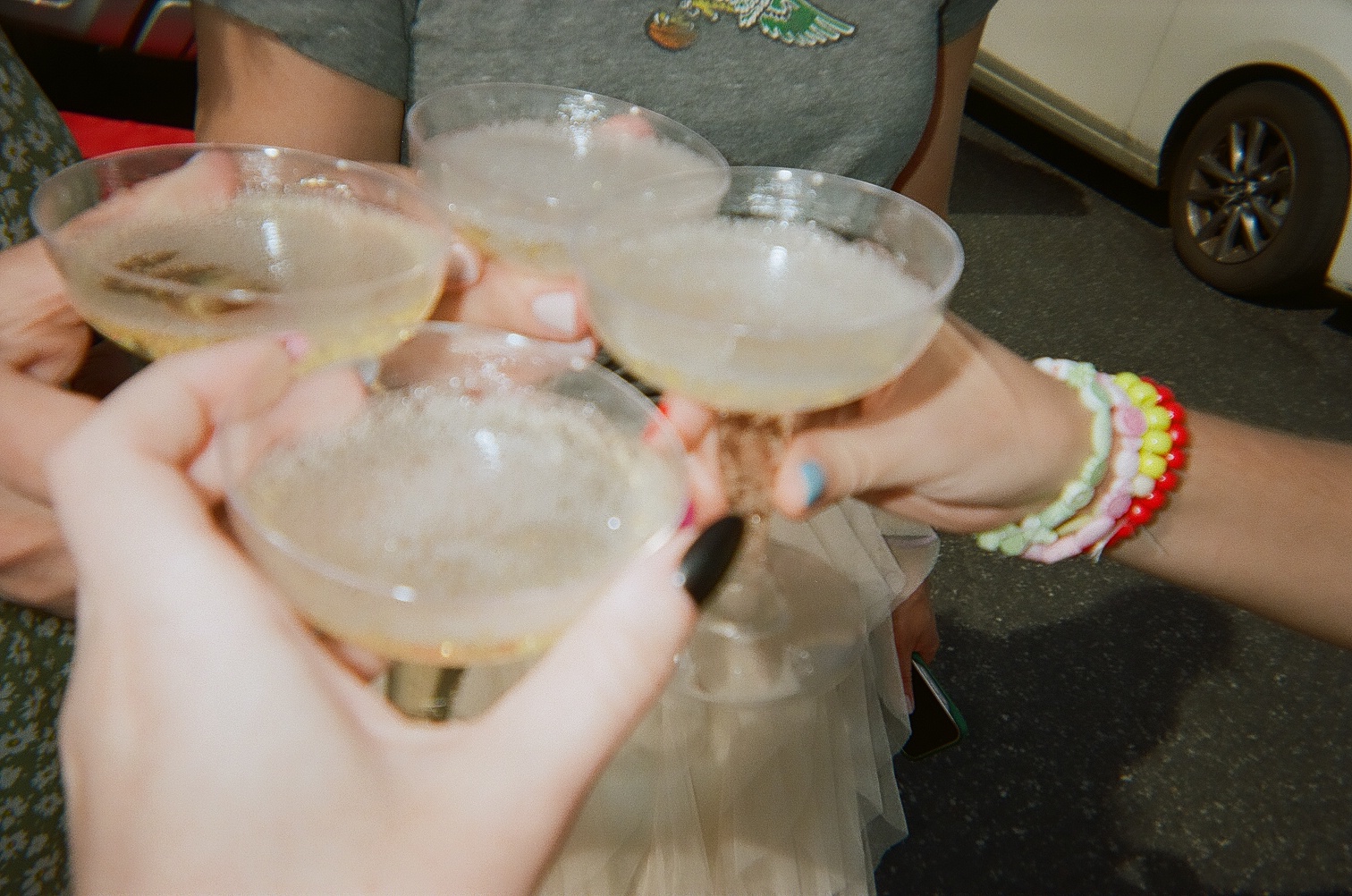Four people toast with champagne glasses.