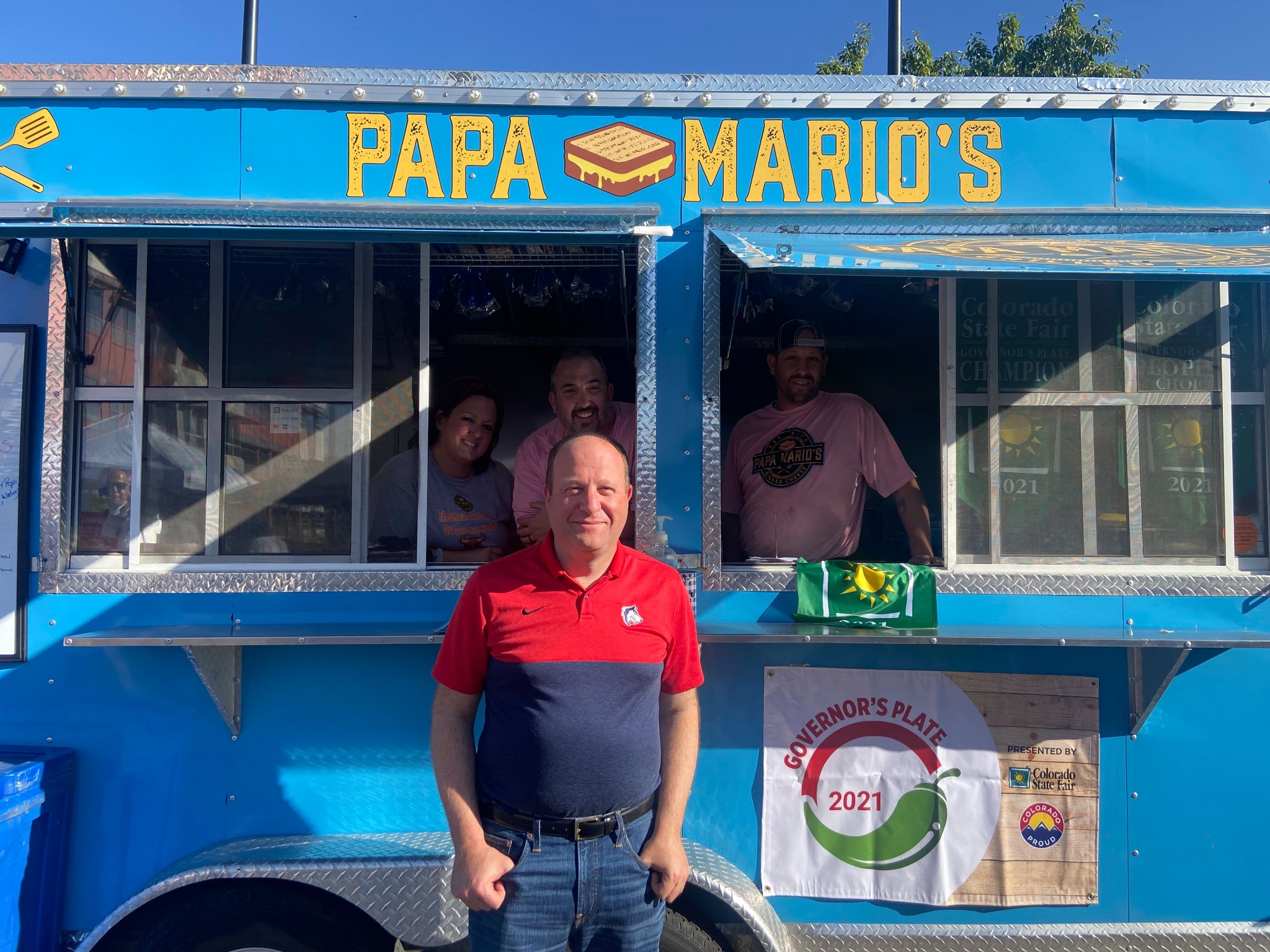 Governor Polis in front of the Papa Mario's food truck.