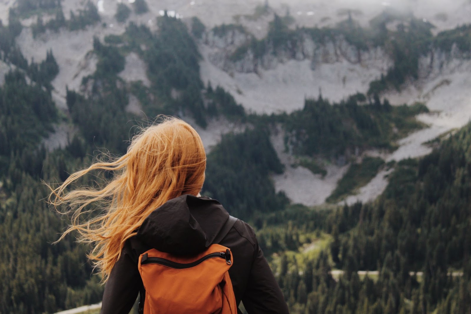 woman looking at a mountain thinking about post travel depression
