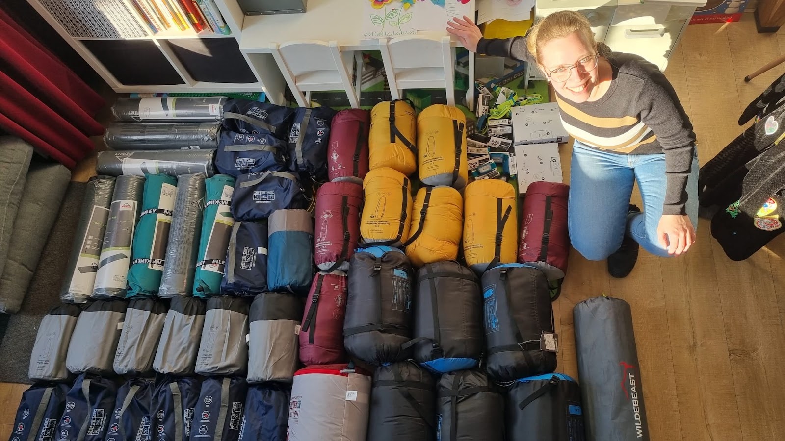 A volunteer helping with collecting large amount of sleepingbags for adults.
