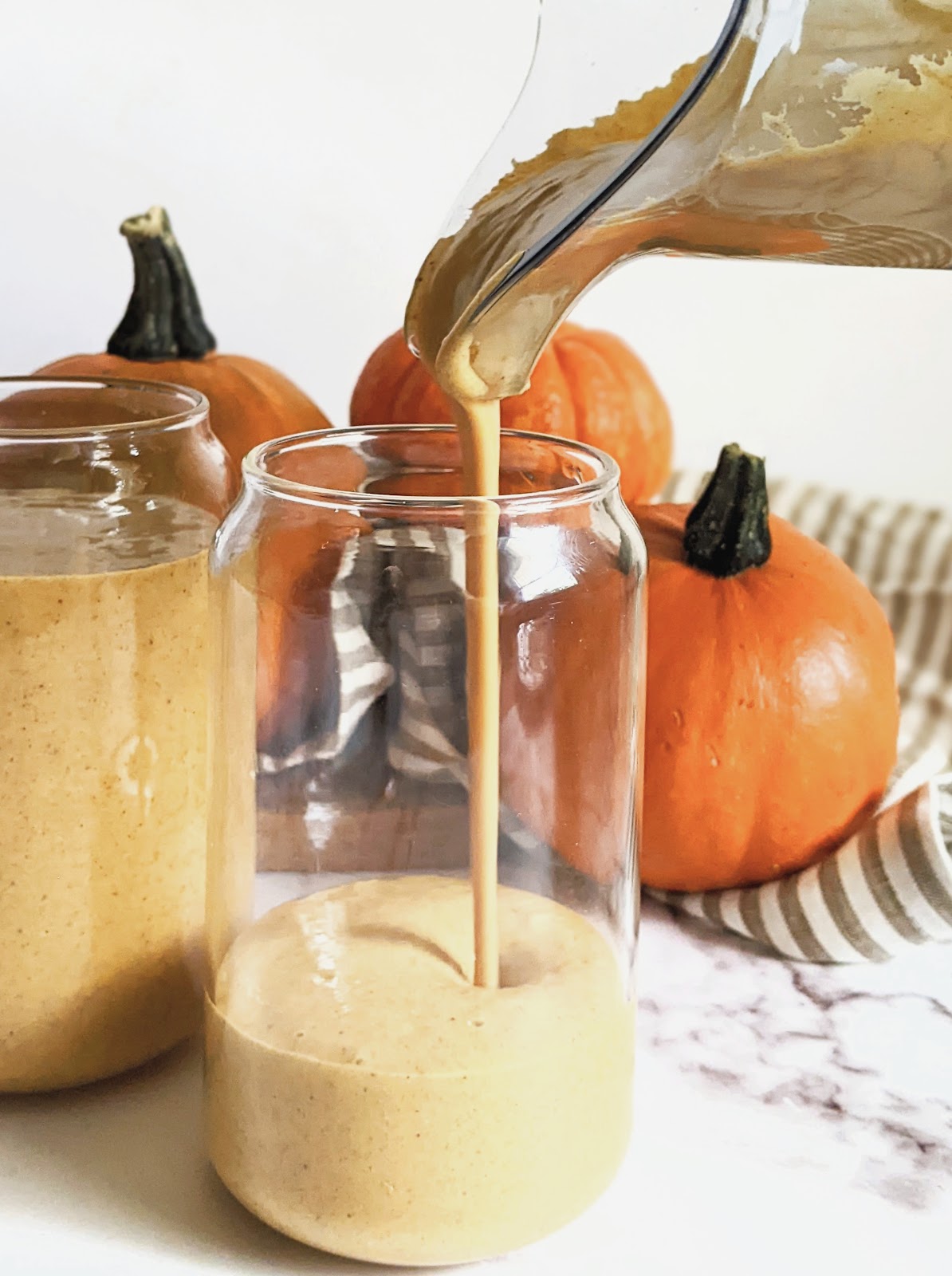 side view of pumpkin pie smoothie being poured into a glass
