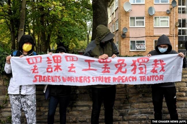 示威者在中国驻曼彻斯特领事馆外手持北京四通桥悬挂反习标语的横幅举行抗议。中国驻曼彻斯特领事馆工作人员随后出来把示威者扯进领事馆内进行殴打。(2022年10月16日)