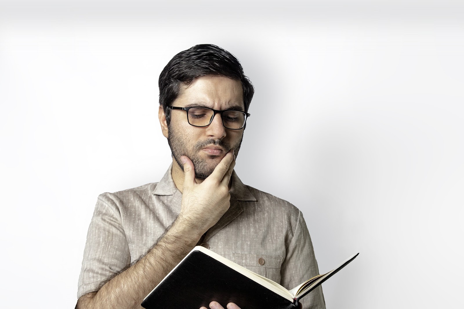 A picture of a man pondering what's written in an academic journal