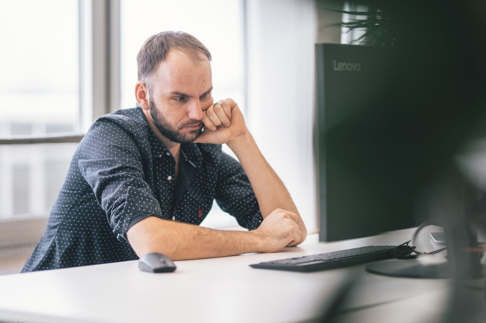 A man thinking in front of a computer