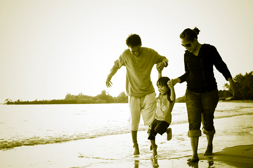 Man, woman and child playing on the beach