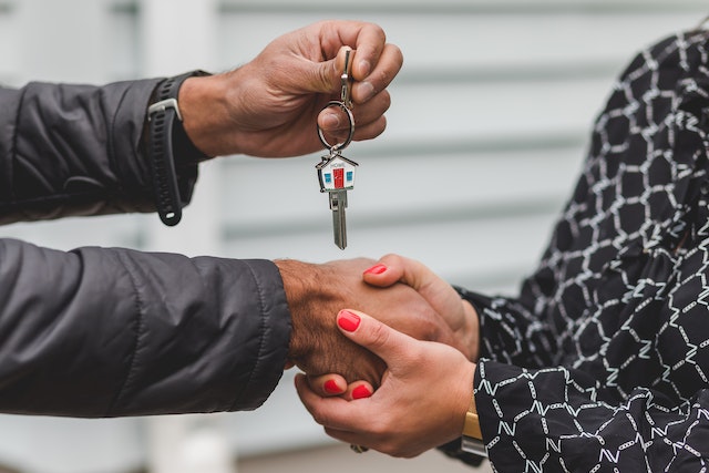 single-family homes in Oxford AL, this image shows a person handing over a key to another person