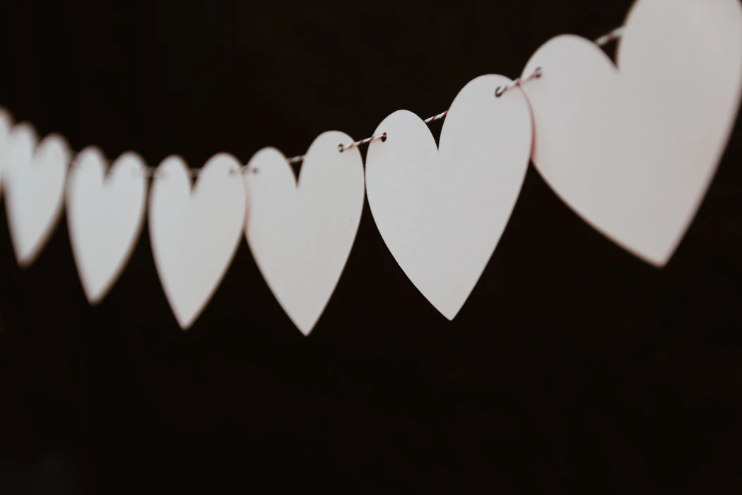 A row of white paper hearts on a string