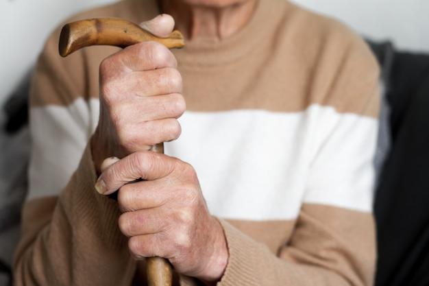 Closeup of the hands of a very elderly person in a beige sweater health concept Premium Photo