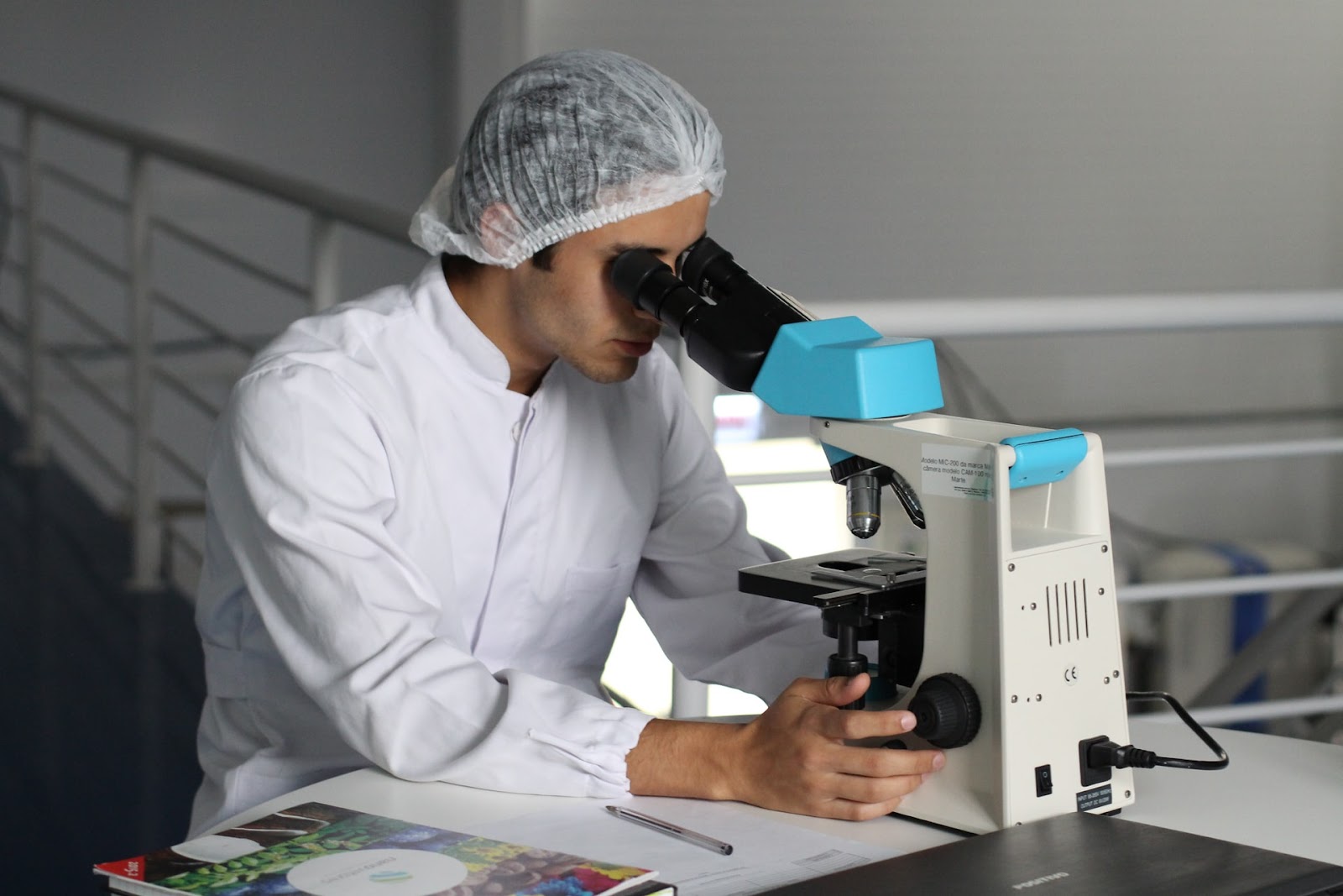A picture of a medical researcher looking through a microscope, representing research funded by The Everest Foundation