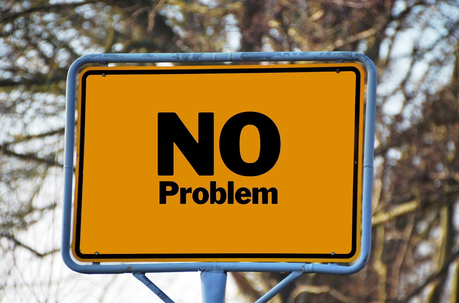 A yellow road sign displaying the words No Problem