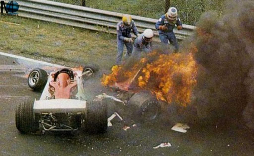 Momento exacto en el que socorren los pilotos Harald Ertl, Guy Edwards y Arturo Merzario, junto a 5 espectadores y un policía socorren a Niki Lauda tras colisionar