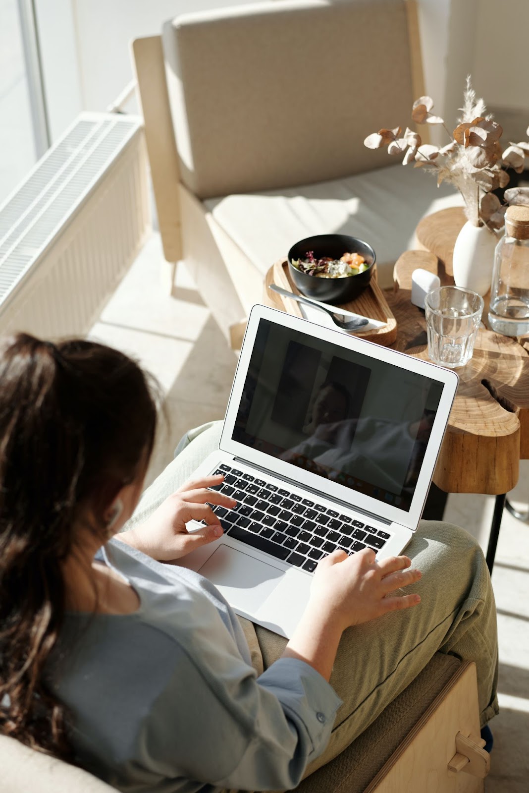 A person sitting and looking at their laptop.