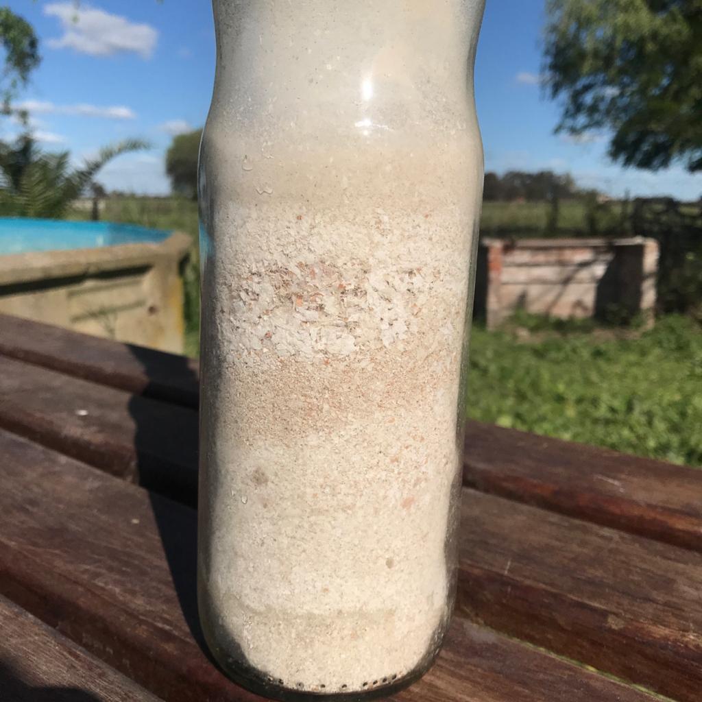 Una botella de vidrio llena de polvillo de cáscaras de huevo. 