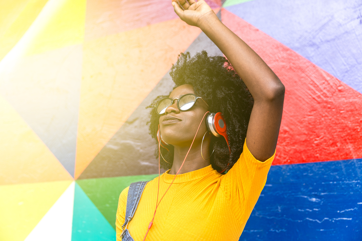 Mulher em psicodélicos usando fones de ouvido enquanto ouve música.