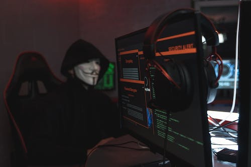 Free Person in Black Hoodie Hacking a Computer System Stock Photo