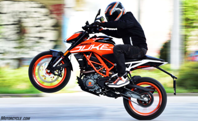 KTM 390 Duke rider performing thrilling wheelie on orange motorcycle