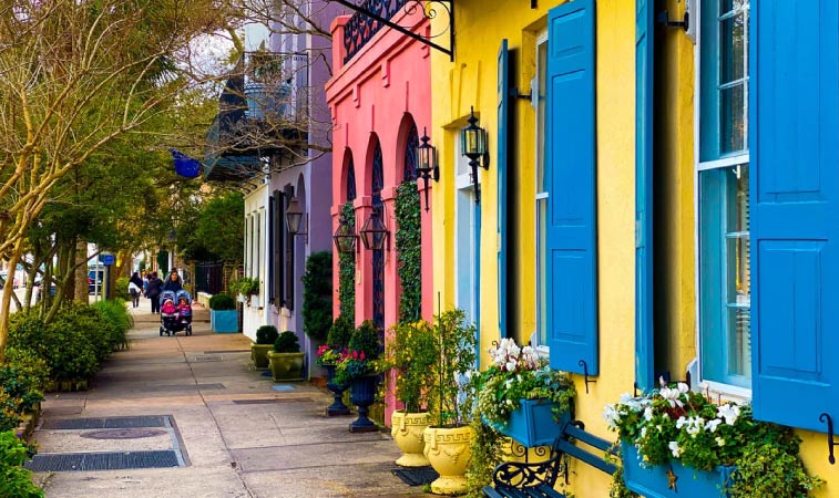 The facades of brightly colored row homes on Rainbow Row in Charleston, SC