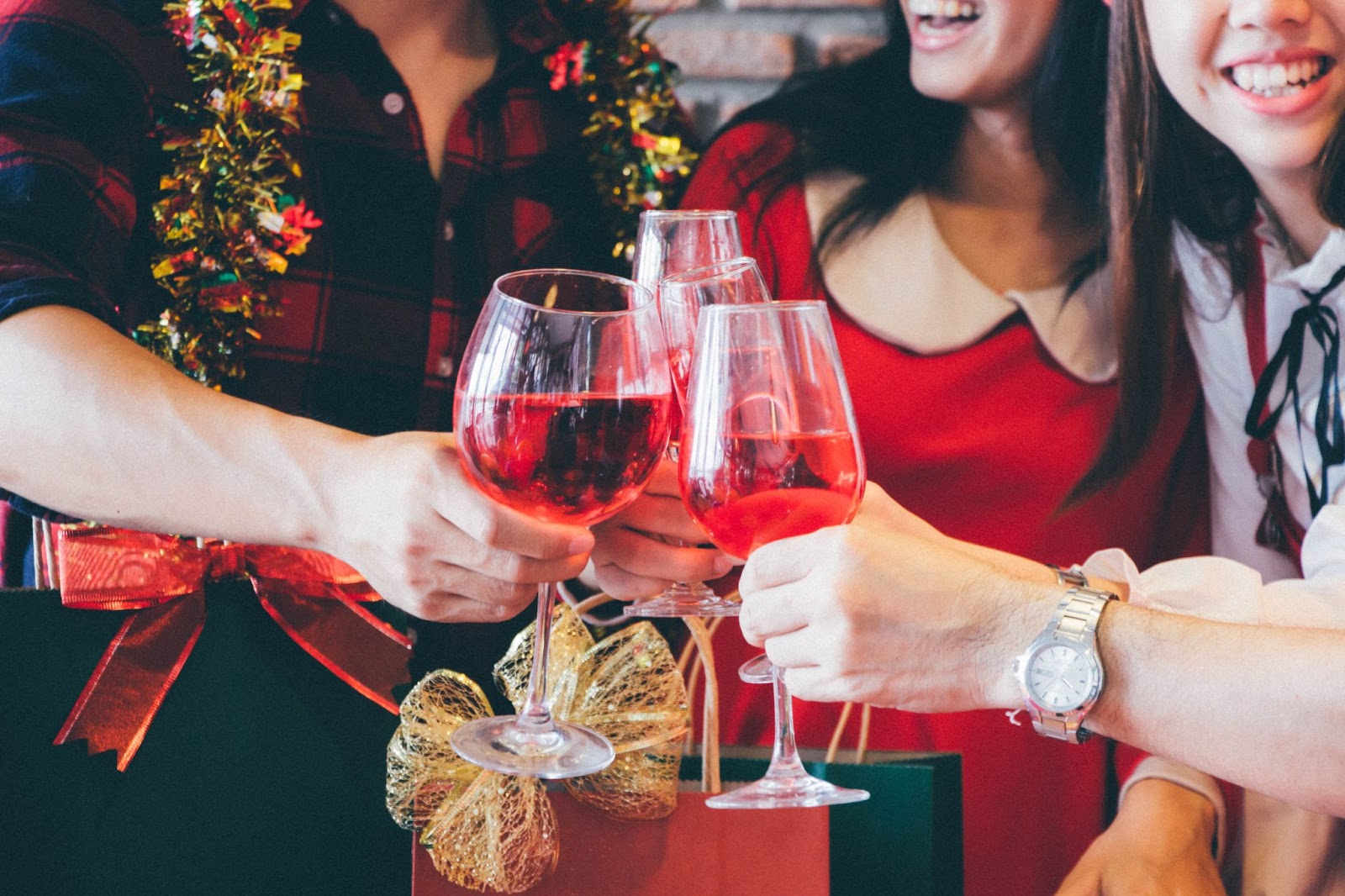 A group of friends share a bottle of wine after exchanging Christmas gifts