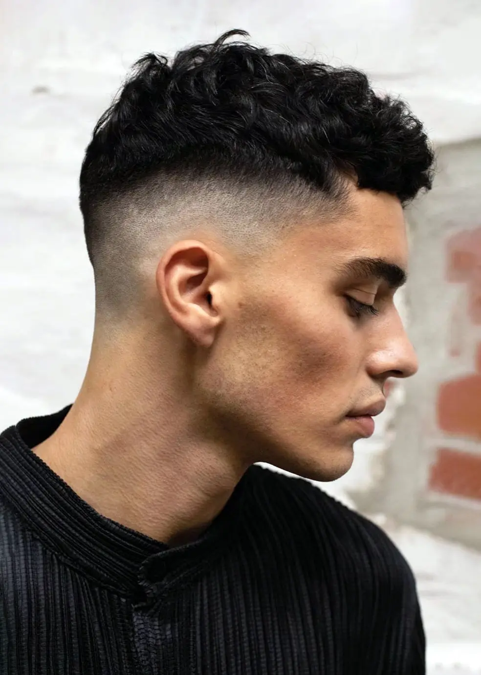 side view of man wearing mid fade with short hair