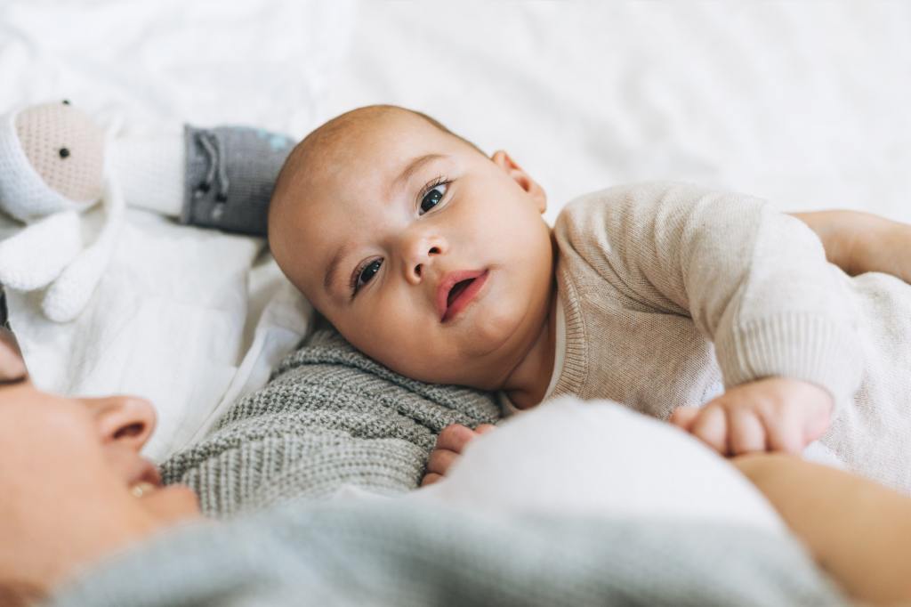 mother and bag lying on bed