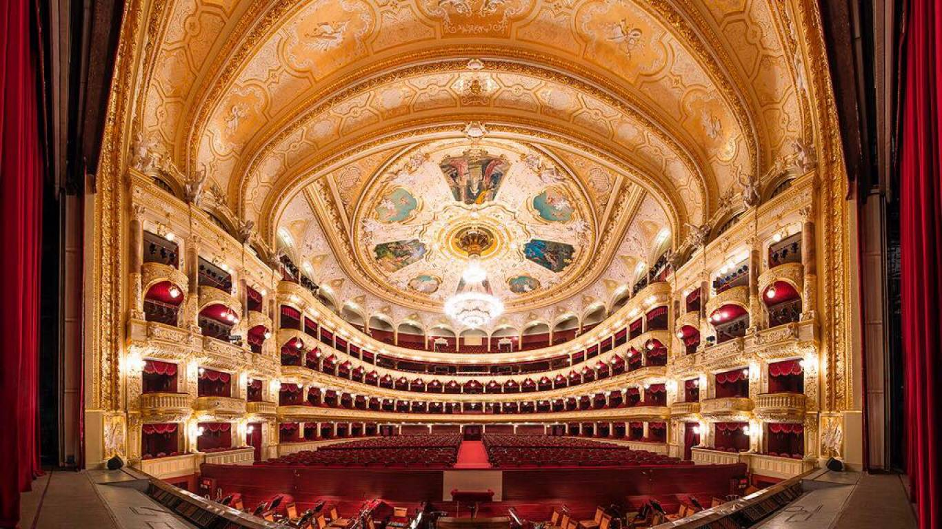 Червоний оксамит сидінь в Одеському Оперному театрі переливається з позолотою на дереві.
