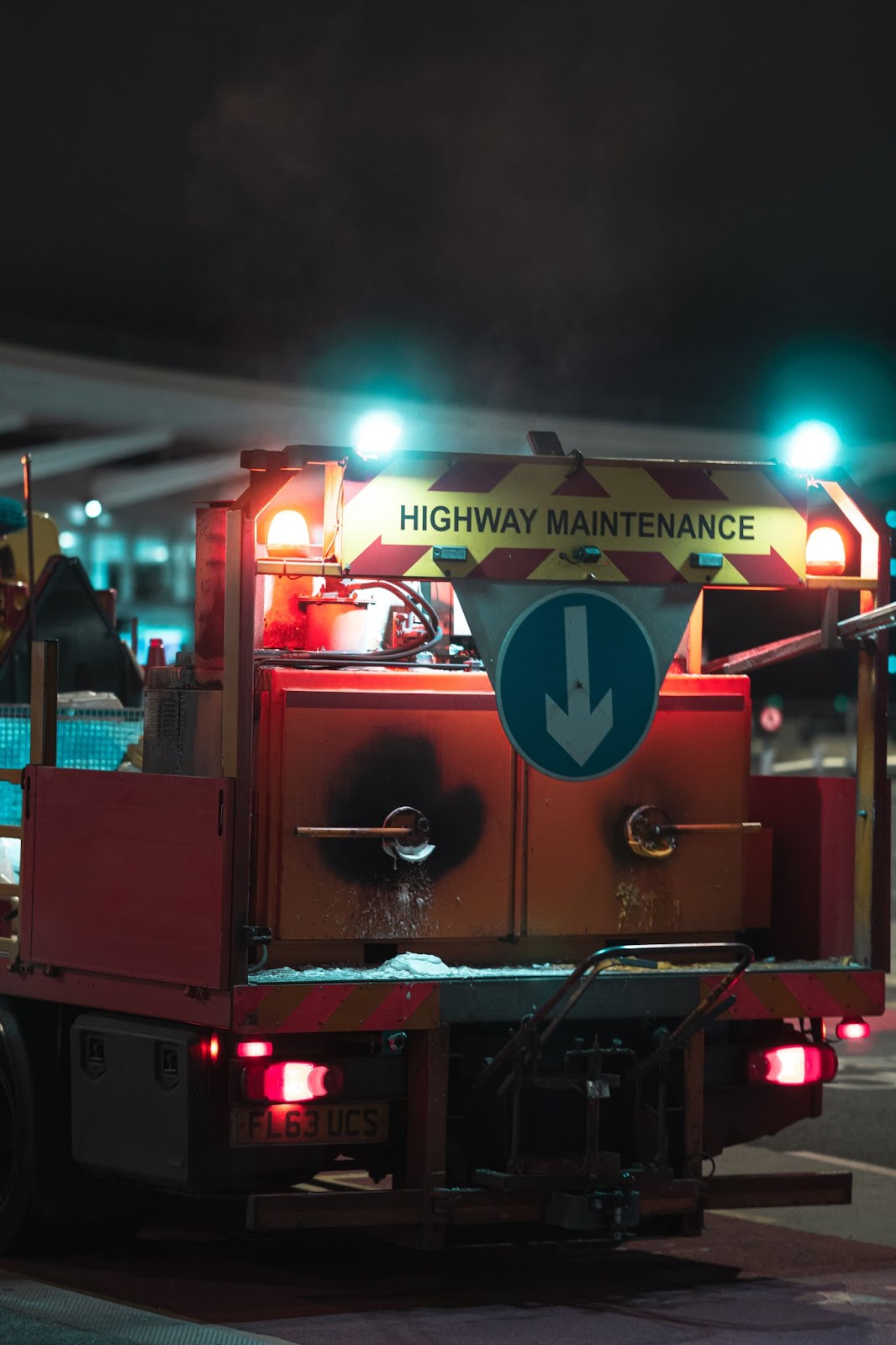 A highway maintenance truck with its lights on at night